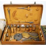 An early 20th century brown leather clad travelling vanity case, matched contents to include various