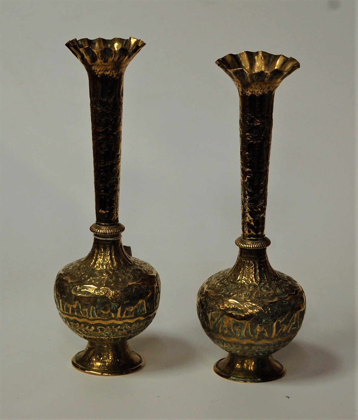 A pair of Indian brass vases, each having a flared rim to a slender tapering neck and bulbous