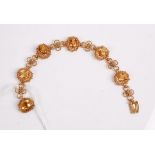 A yellow metal and citrine set bracelet, the 6 claw set oval cut citrines each in wire work