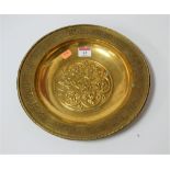 An early 20th century brass church offering bowl of circular form, the centre relief decorated