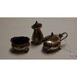 A harlequin three-piece silver cruet, comprising mustard with blue glass liner, open salt with
