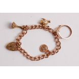 A 9ct gold charm bracelet, containing a small number of charms, fob seal, and heart shaped padlock