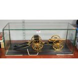 A large hand built gold plated model of an artillery canon within glazed display case, case