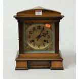 A late 19th century continental walnut cased mantel clock having a silvered dial with Arabic
