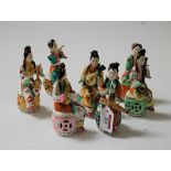 A set of eight continental porcelain figures, each in the form of a seated lady playing an