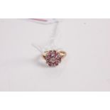 A modern 9ct gold, ruby and diamond highlight set flower head cluster ring, 2.7g, size M