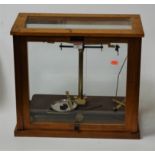 A pair of mid 20th century teak cased chemists scales bearing a label for Griffin & George Ltd,