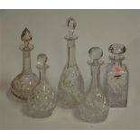 An Edwardian cut glass decanter and stopper of onion shape, together with four other decanter and