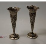A pair of early 20th century Persian white metal trumpet shaped spill vases, each having relief
