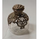 An Edwardian glass scent bottle and stopper, having pierced silver mount, the hinged cover relief