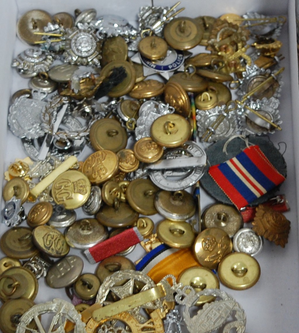 A box of various military cap badges (re-strikes), military buttons, medal ribbons etc