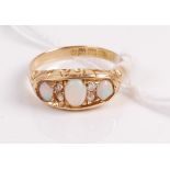 A vintage 18ct gold opal and diamond ring arranged as three cabochon opals each dispersed with two