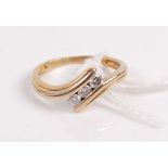 A yellow metal diamond wishbone ring, centre set with three brilliants, total diamond weight