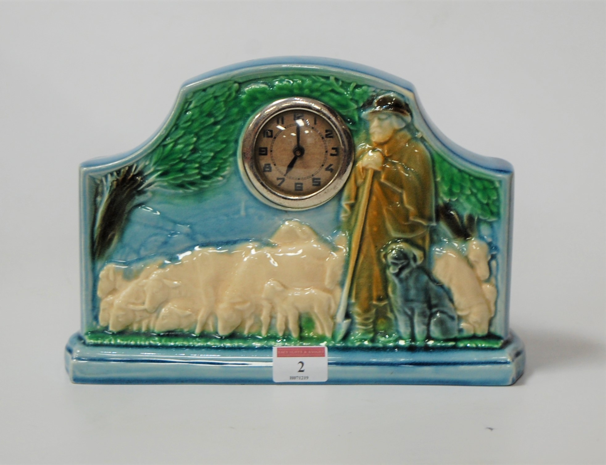 An early 20th century French Sarreguemines pottery mantel clock, the case relief decorated with a