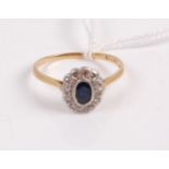 A vintage 18ct gold sapphire and diamond cluster ring, arranged as an oval cut sapphire in a