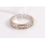 An 18ct gold diamond half eternity ring channel set with 9 small brilliants, total diamond weight