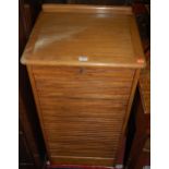 A 1920s round cornered oak ledge back tambour fronted office filing cabinet, fitted with slides (