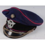 A WW II style German Fire Police NCO's peaked visor cap, in blue felt with black band and red trim.