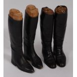 A pair of mid-20th century black leather calf length riding boots, with wooden trees, together