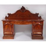 A large mid-Victorian mahogany and flame mahogany twin pedestal serpentine front sideboard, having a