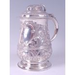 A George II silver tankard, having a dome top hinged cover and S-scroll handle, the whole later