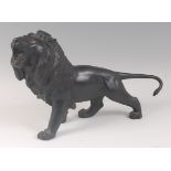 A Japanese Meiji period (1868-1912) bronze lion, in striding roaring pose, with original glass eyes,