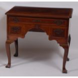 An early George III mahogany and crossbanded lowboy, the moulded top having pinched corners over