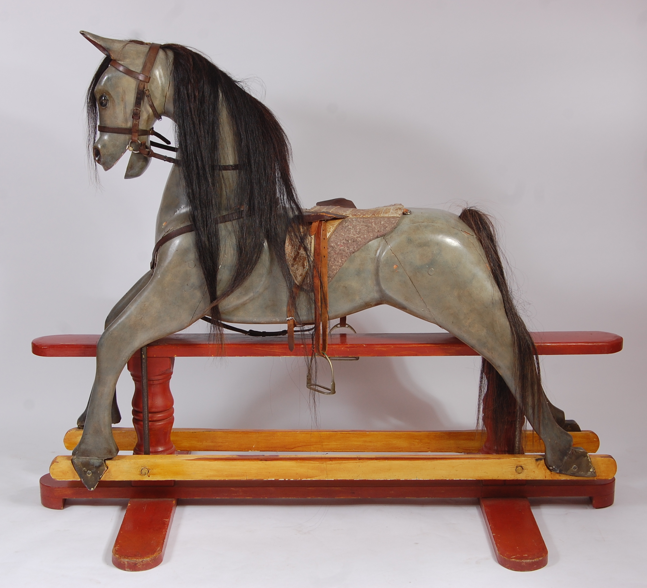 A large early/mid 20th century painted pine dapple grey rocking horse , having a partially leather