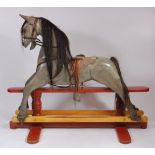 A large early/mid 20th century painted pine dapple grey rocking horse , having a partially leather