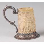 A 19th century Germanic ivory and silver mounted miniature tankard, the body carved in relief with a