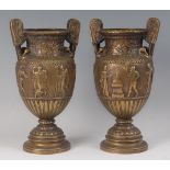 A pair of early 20th century bronze twin handled pedestal Townley style vases, the bodies each