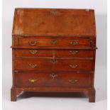 A mid-18th century walnut writing bureau, the crossbanded and feather strung sloping fall opening to
