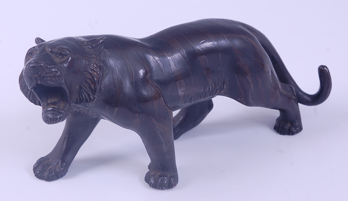 A Japanese Meiji Period (1868-1912) bronze Tiger, in standing roaring pose, with patinated stripes