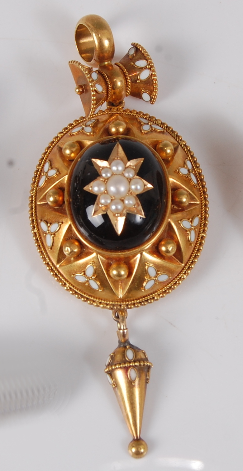 A late Victorian yellow metal target style mourning pendant, featuring a centre black hardstone
