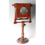 An early 19th century mahogany pedestal zograscope, the rectangular hinged mirrorplate and