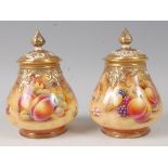 A pair of Royal Worcester porcelain pot pourri vases and covers, each painted with fruit on a