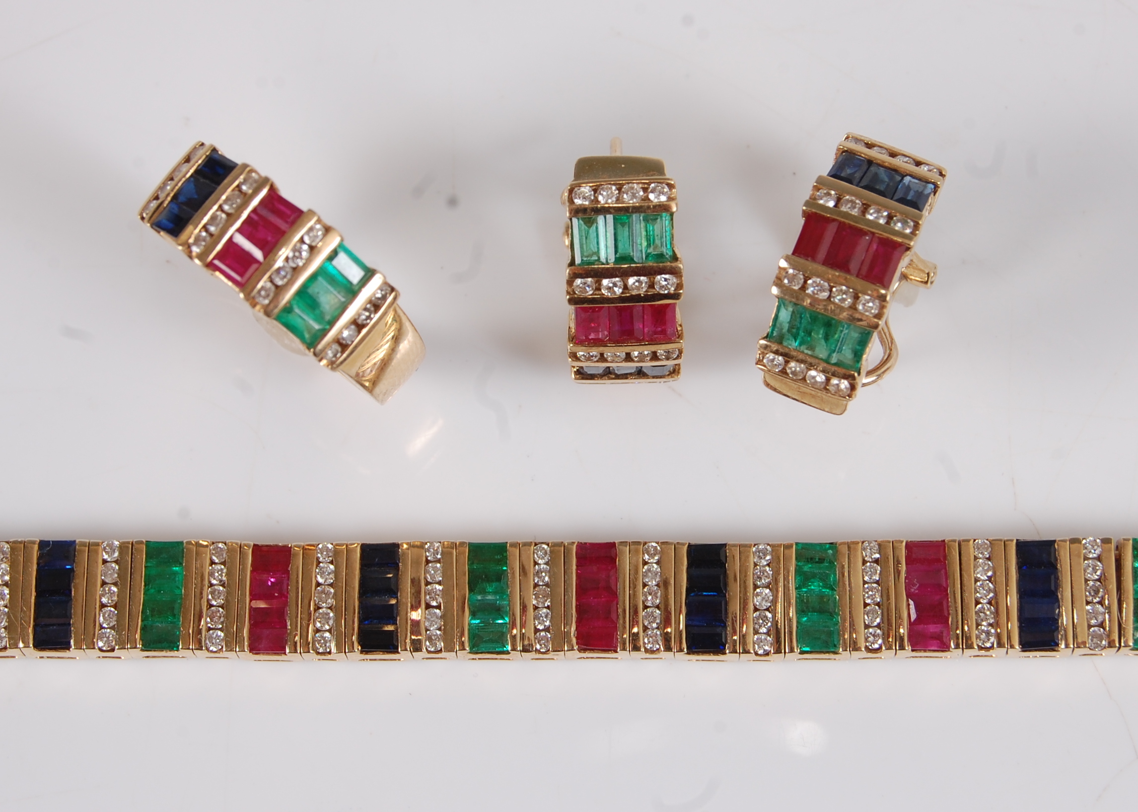 An 18ct gold multi-stone suite of jewellery, comprising bracelet, pair of earrings, and a ring, each
