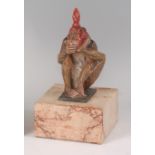 After Bruno Zach - a cold painted bronze model of a seated monkey wearing a red knotted headscarf,