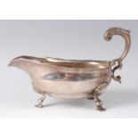 A George II silver sauceboat, having acanthus leaf capped flying C-scroll handle, all raised on