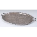 A circa 1900 Indo-Persian silver twin handled tray, of shaped oval form, having trailed and finely