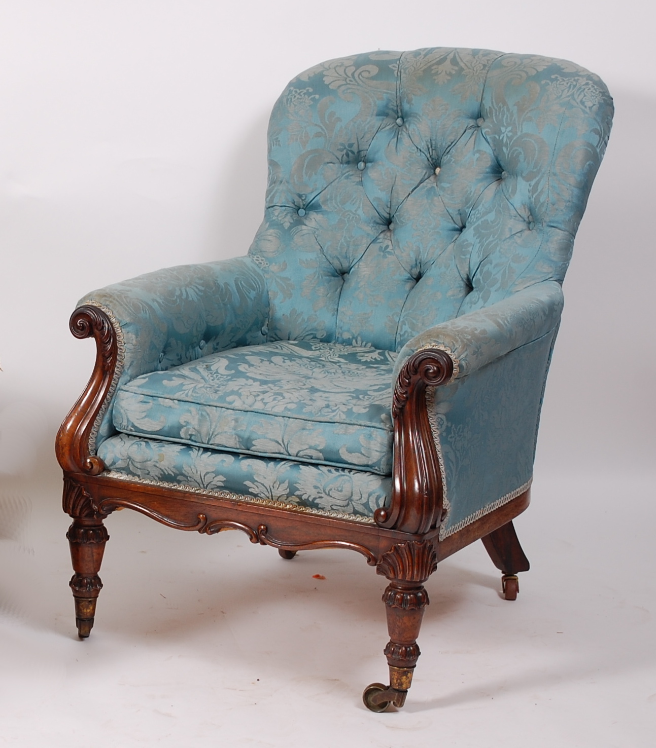 An early Victorian rosewood framed spoonback armchair, the whole upholstered in a silk blue