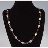 A contemporary moonstone and opal necklace, arranged as alternating cabochon stones, each