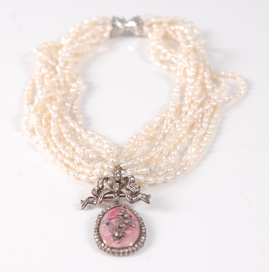 A ten row twisted baroque freshwater pearl necklet, with an oval pendant in pink guilloche with