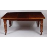 A late Victorian mahogany extending dining table, the top having a moulded edge, three extra