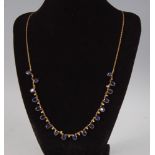 A contemporary yellow metal, sapphire and diamond set fringe necklace, arranged as eighteen oval cut