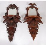 A pair of late 19th century Black Forest carved and stained walnut mirrored wall brackets, each