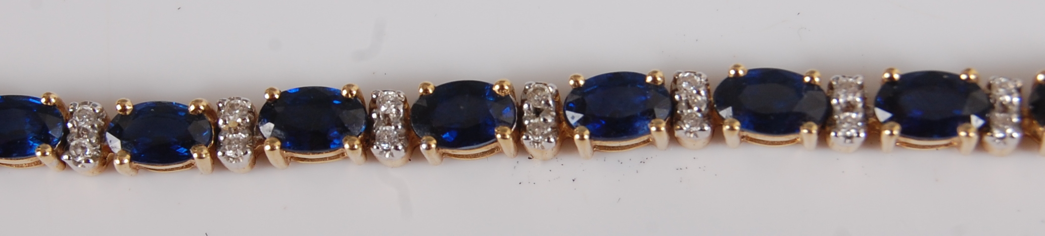 A contemporary 18ct gold, sapphire and diamond point set bracelet, arranged as 25 four-claw set oval - Image 2 of 2