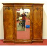 A Victorian figured walnut breakfront fitted wardrobe, having a moulded cornice and centre mirror