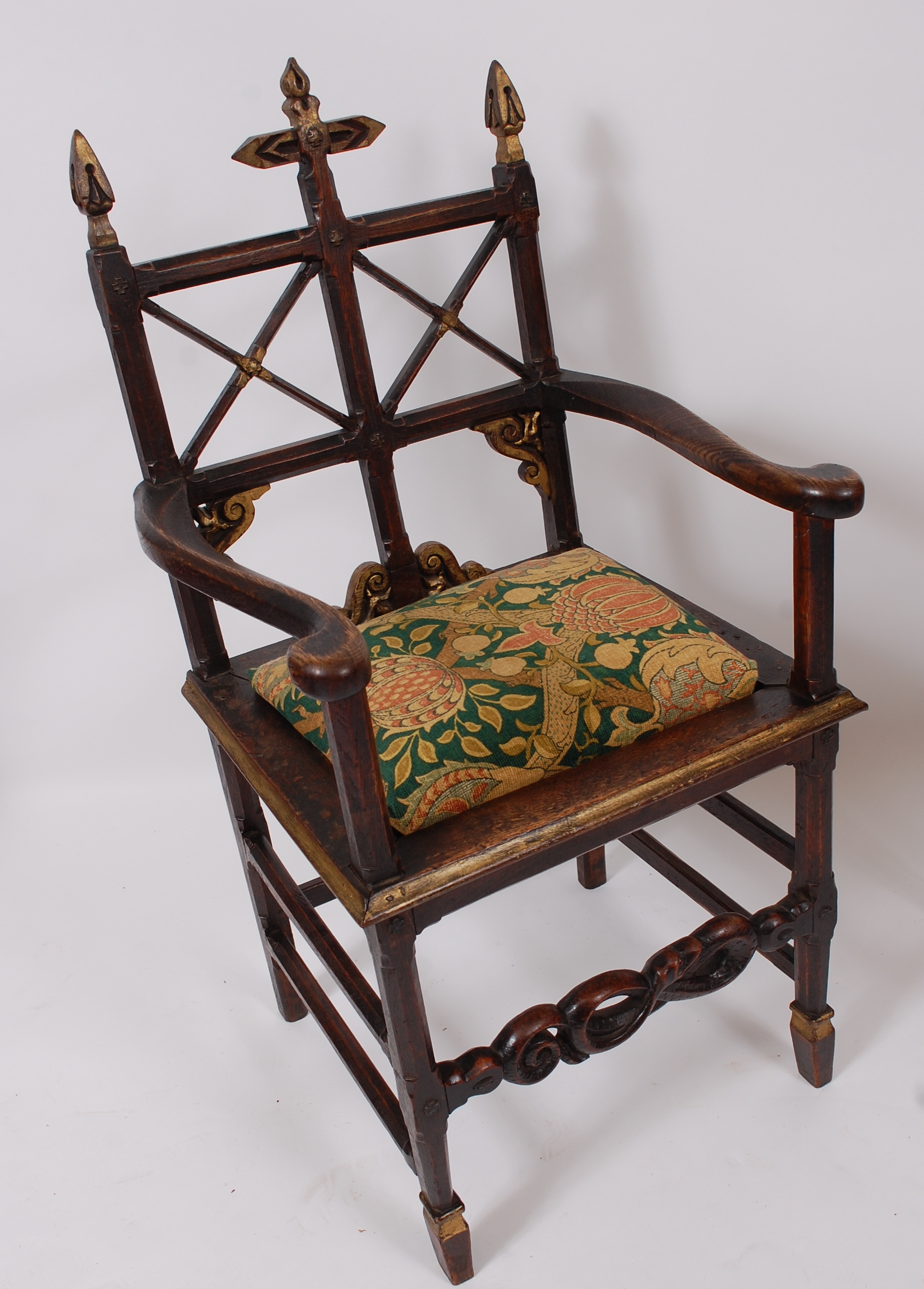 A Victorian oak and gilt decorated elbow chair, in the ecclesiastical style, having pad seat, w.