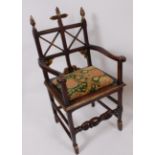 A Victorian oak and gilt decorated elbow chair, in the ecclesiastical style, having pad seat, w.